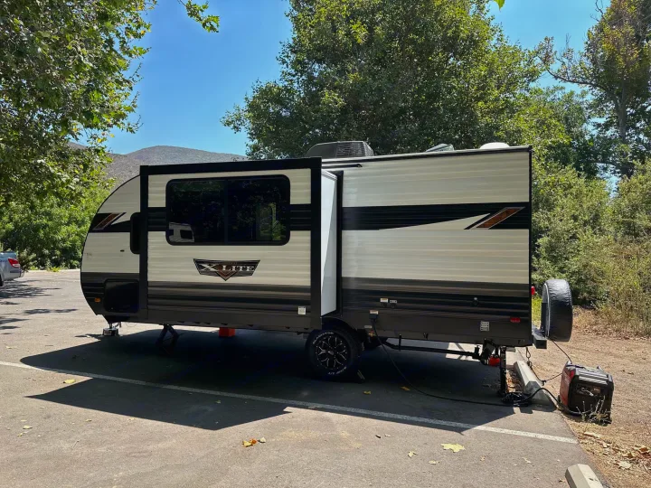Spacious RV rental, with slide-out extended and generator running, ready for a peaceful escape in the mountains.. Forest River Wildwood Platinum 2024