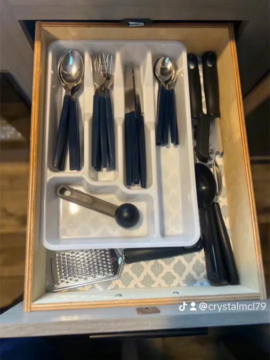 Neat RV rental kitchen drawer with organized cutlery, grater, can opener, and scoop. Essential utensils for your journey.. Dutchmen Coleman Lantern LT 2024