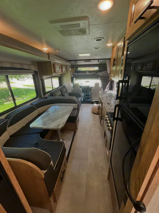 Bright RV rental interior: modern kitchen, cozy dinette, and scenic windows for your next travel adventure.. Coachmen Leprechaun 2021