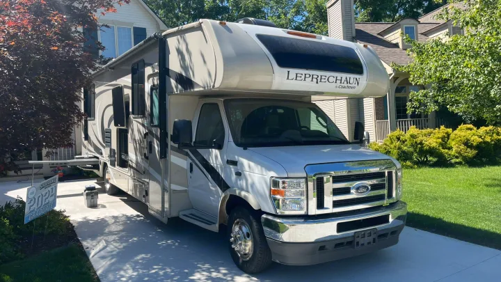 Spacious Class C RV rental, a Leprechaun by Coachmen, parked on a sunny driveway for your next adventure.. Coachmen Leprechaun 2021