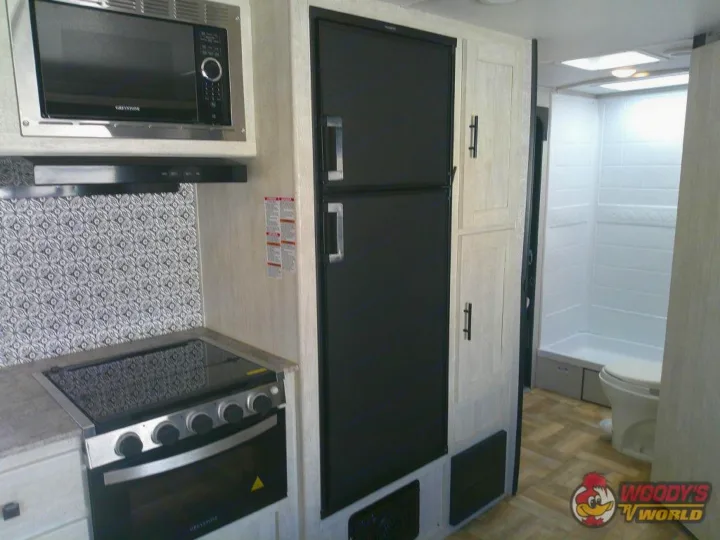 Modern RV rental interior featuring a full kitchen with microwave, stove, fridge, and a bathroom with shower/toilet.. Forest River Shasta 2022