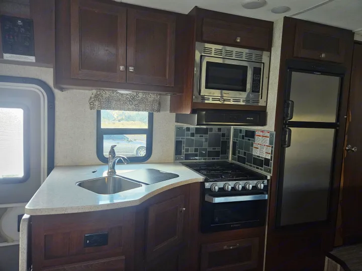RV rental kitchen: sink, stove, microwave, fridge, and ample cabinets. Perfect for your travels.. Forester Forester Motorhome 2020