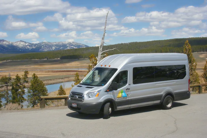 Silver WanderVans RV rental overlooks scenic mountains, a river, and forest under a cloudy blue sky.. Ford transit 2021
