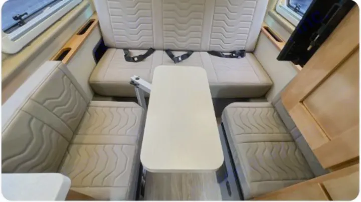 Spacious RV rental dinette: comfortable seating with textured cushions & table. Ideal camper interior.. Coachman Nova 2024