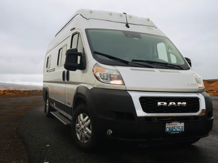 White Winnebago Ram ProMaster RV rental parked outdoors under a cloudy sky, ready for a road trip adventure.. Other Other 2022