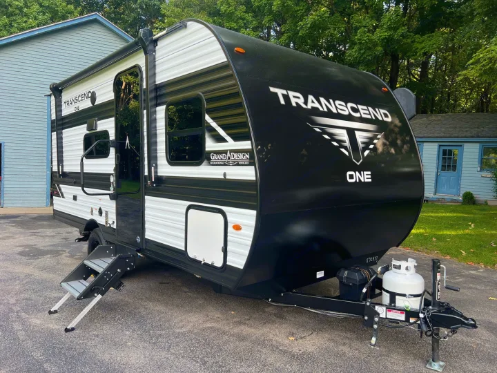 This Grand Design Transcend One travel trailer, ready for rv rental adventures, is parked on a driveway.. Grand Design Transcend One 151BH 2025