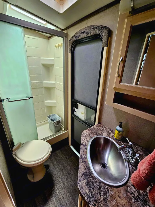 Step inside this RV rental's compact bathroom, featuring a shower, toilet, and a sink vanity for your comfort.. Minnie Minnie Plus 2019