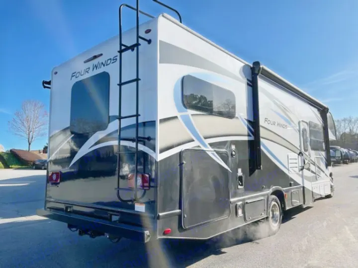 Rear 3/4 view of a sleek black, white, and grey Thor Four Winds Class C motorhome, an ideal rv rental.. Thor Four Winds 2022