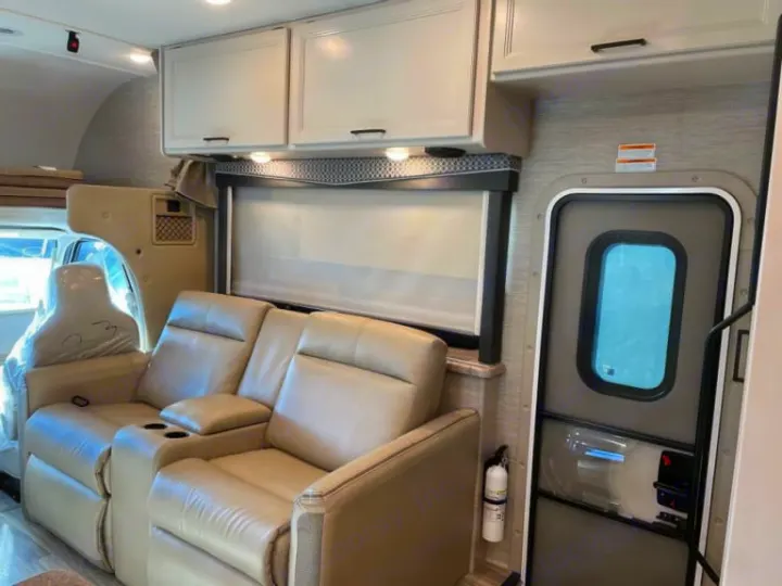 Relax in this RV rental with tan recliners, overhead storage, and a convenient entry door.. Thor Four Winds 2022