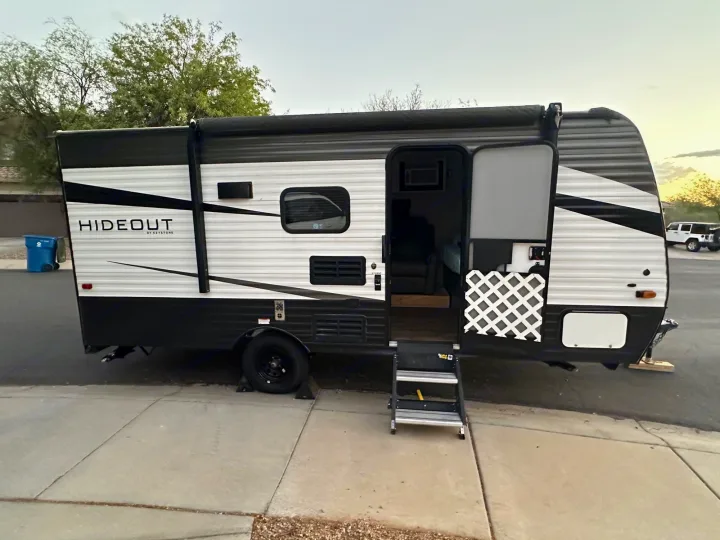 Black and white Hideout travel trailer, door open with steps, ready for your next RV rental adventure.. Keystone RV Hideout 2021