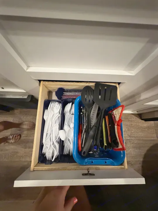 An RV rental's well-organized kitchen drawer, featuring plastic cutlery & handy cooking utensils for travel convenience.. Keystone RV Hideout 2021