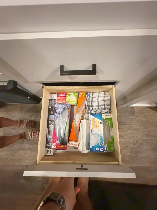 RV rental kitchen drawer stocked with organized essentials: trash bags, foil, matches, and a dishtowel for easy access.. Keystone RV Hideout 2021