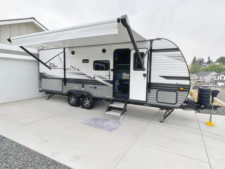 A modern Jayco Flight travel trailer with its awning out, parked on a driveway. Ready for your next rv rental adventure.. Jayco Jay Flight 2024