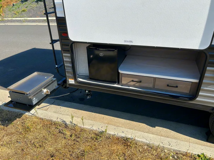 RV rental featuring an outdoor kitchen: Blackstone griddle, mini-fridge, and pull-out storage. Perfect for camping!. Jayco Jay Flight 2024