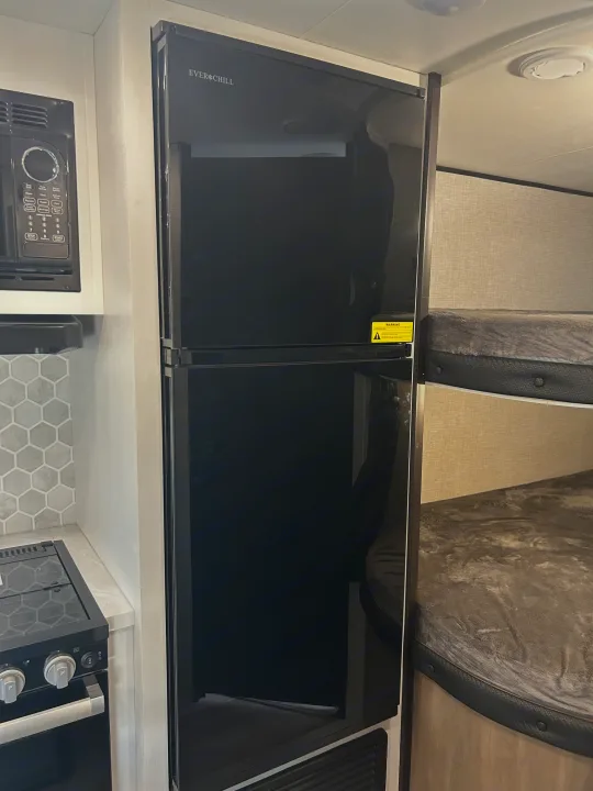 RV rental interior: A practical space with TV, laundry hookups, and bathroom vanity, perfect for travel comfort.. Jayco Jay Flight 2024