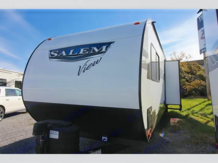 White Salem View travel trailer RV for rental, showing its curved front, black trim, and propane tank. Parked outdoors.. Forest River Salem 2024
