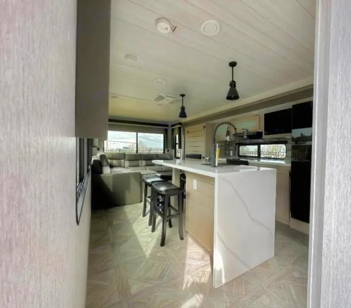 Spacious and modern rv rental interior featuring a stylish kitchen island, comfortable living area, and large windows.. Forest River Salem 2024