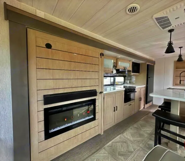 Modern RV rental interior featuring a full kitchen, sleek electric fireplace, and dining island for comfortable travel.. Forest River Salem 2024