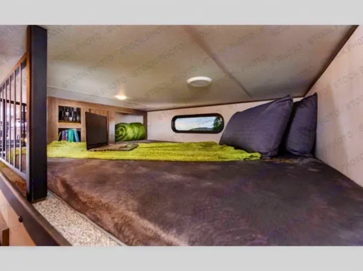 RV rental: Cozy cabover bunk features a bed, TV, storage, and a window with a scenic view, perfect for travel.. Forest River Sabre 2021