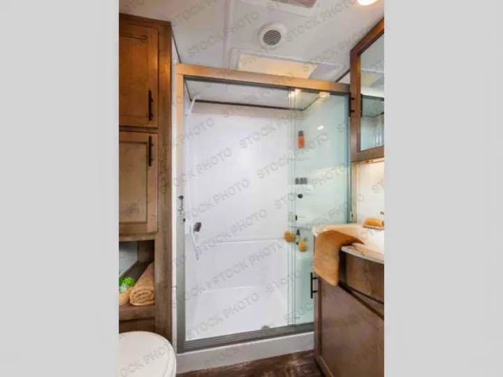 Inside an rv rental: a clean, modern RV bathroom with a glass shower enclosure & vanity area.. Forest River Sabre 2021