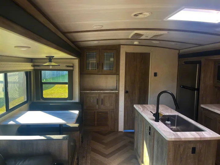 Spacious modern rv rental interior with a well-equipped kitchen, dining area, and multiple windows.. Forest River Salem Hemisphere 2020