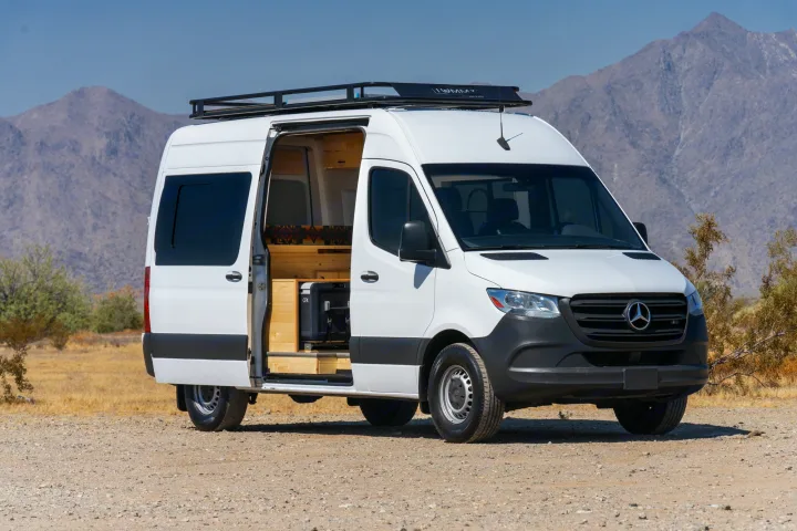 White Mercedes-Benz Sprinter camper van, an RV rental, parked in the desert mountains with its custom interior.. Mercedes-Benz Sprinter 2021