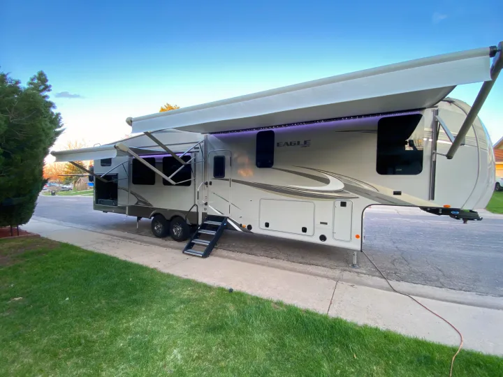 Spacious fifth-wheel RV with extended awnings, steps, and purple LED lights, ideal for an rv rental experience.. Jayco Eagle 2020