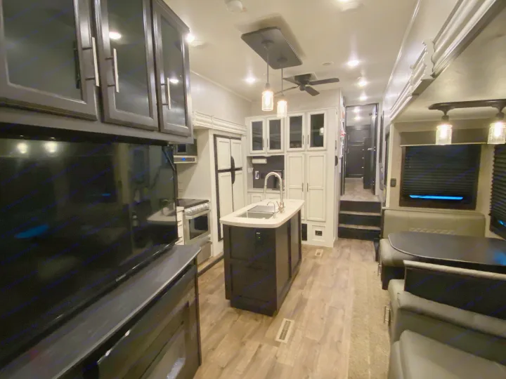 Explore this well-equipped RV rental, showcasing a modern kitchen with island, cozy dinette, and spacious living area.. Jayco Eagle 2020