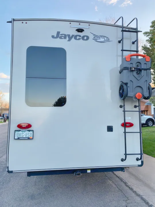 This Jayco RV rental's rear features a ladder, portable tank, and hitch, ready for camping adventures.. Jayco Eagle 2020