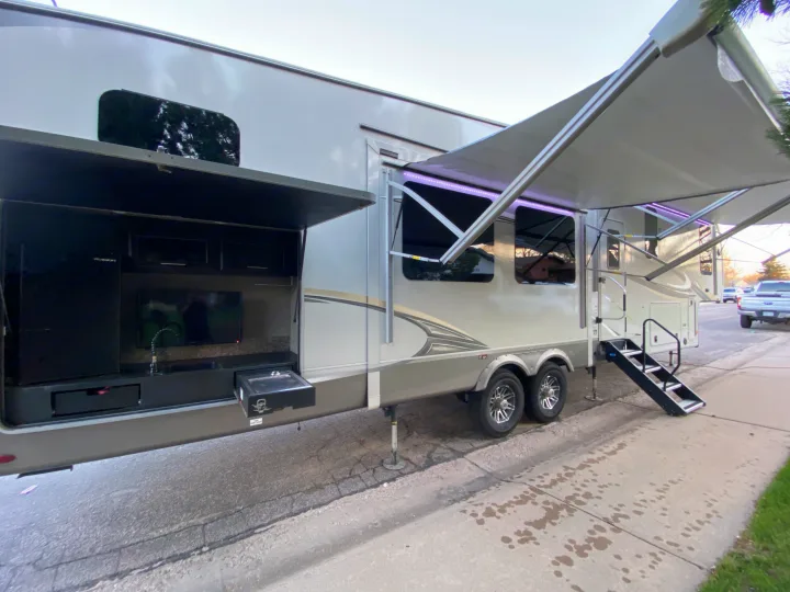 Spacious fifth-wheel RV rental with outdoor kitchen, TV, lighted awning, and steps for adventures.. Jayco Eagle 2020