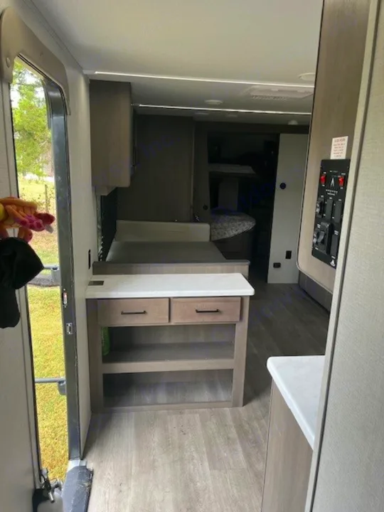 RV rental interior: entryway, storage/counter, dinette, and glimpse of bunk beds in this modern space.. Grand Design Transcend Xplor 2024