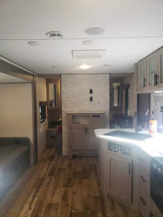 Spacious and modern RV rental interior featuring a full kitchen, living area, and wood floors. Perfect for travel.. Dutchmen Coleman Lantern LT 2022