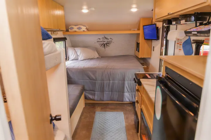 Cozy RV rental interior shows a bed, bunk, kitchen, and dinette, perfect for travel adventures.. Forest River Salem FSX 2023