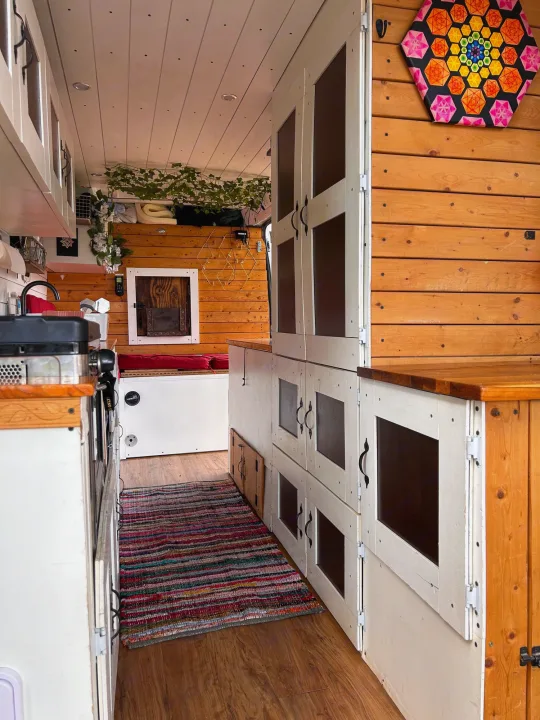 Cozy custom RV rental interior with kitchen, colorful art, and clever storage solutions. Perfect for adventure.. Ram Dodge Promaster 3500 2019