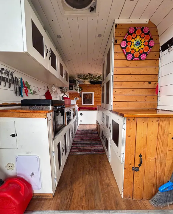 Inside this custom rv rental camper van: a well-equipped kitchen, wood paneling, and smart storage for road trips.. Ram Dodge Promaster 3500 2019