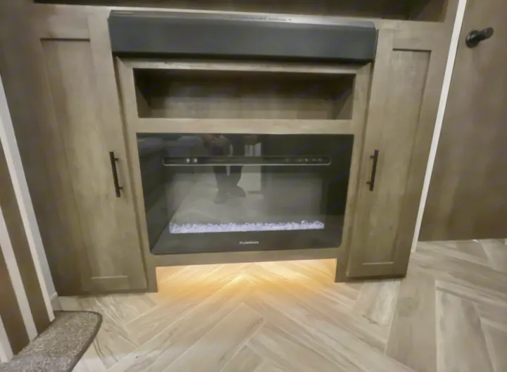 RV rental: Modern living space with electric fireplace, Furrion soundbar, and stylish cabinetry, illuminated floor.. Forest River Wildwood 2022