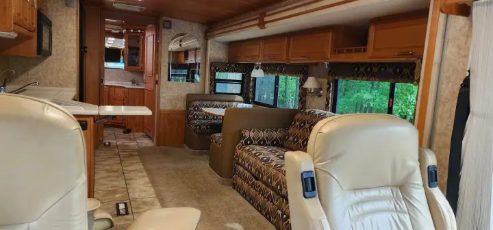 Cozy RV rental interior featuring a living area, dinette, kitchen, and comfortable lounge seating.. Winnebago Journey 2006
