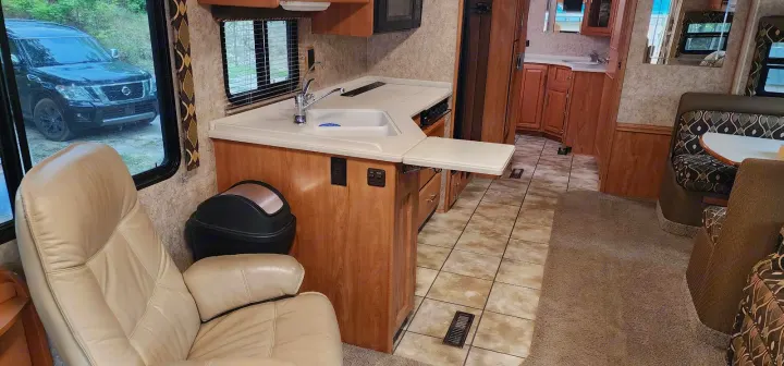 Explore this RV rental's cozy interior, featuring a kitchen, dinette, and plush seating for a comfortable travel experience.. Winnebago Journey 2006