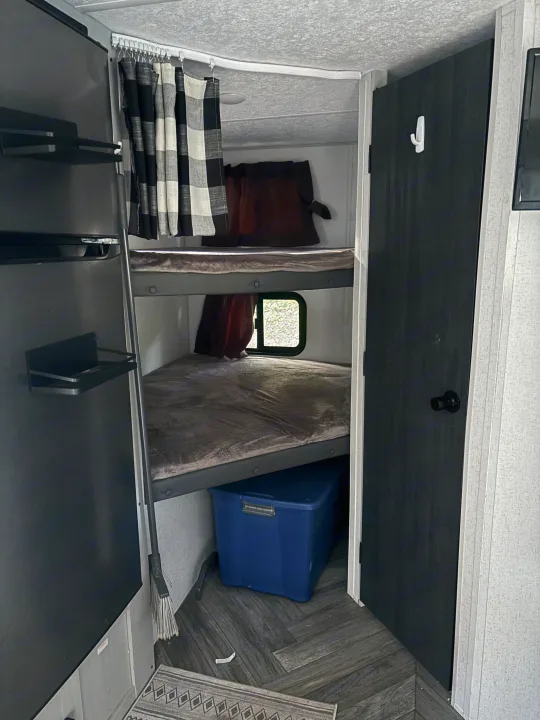 Compact RV rental with cozy bunk beds, a privacy curtain, and storage. Ideal for travel.. Forest River Wildwood FSX Plantium 2022