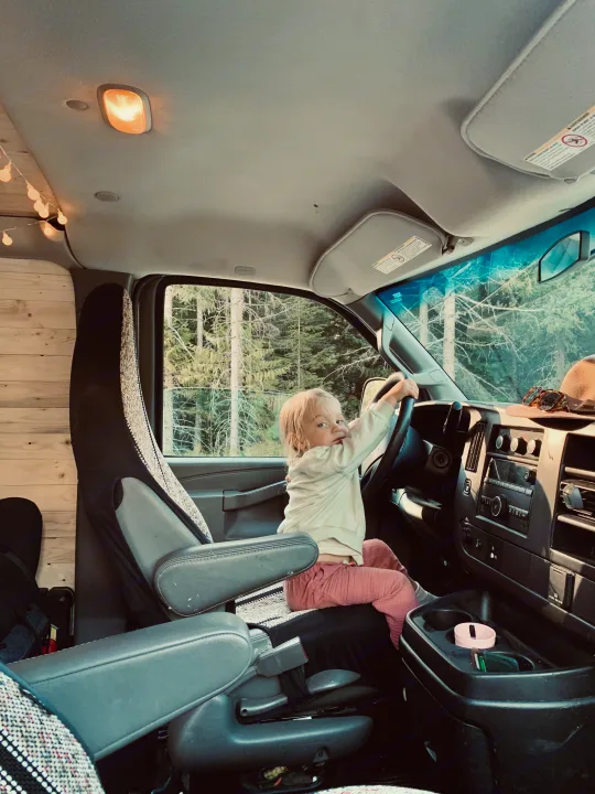 Toddler plays "driver" in a cozy RV rental van, featuring wooden interiors & fairy lights. Adventure ready!. Gmc Savanna 2016