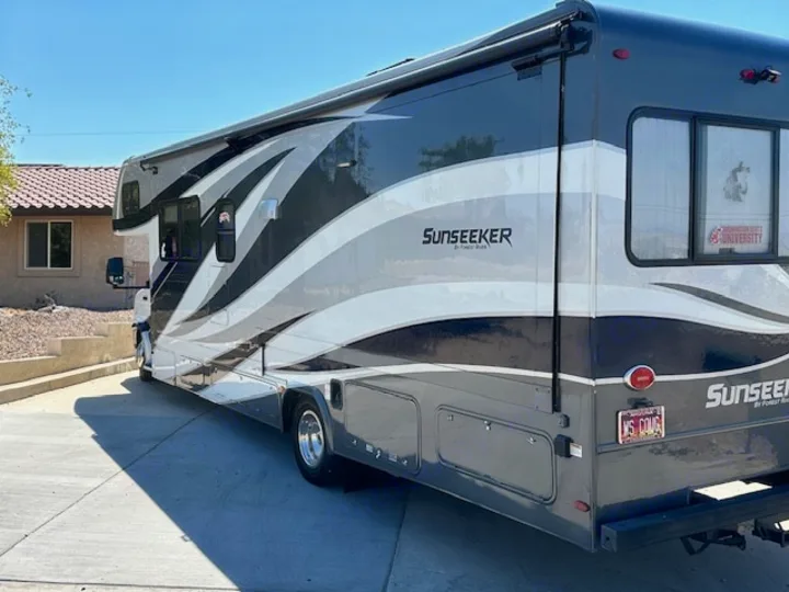 Modern dark gray and white Sunseeker RV parked on a driveway. Great for an rv rental road trip or camping adventure.. Forest River Sunseeker 2018