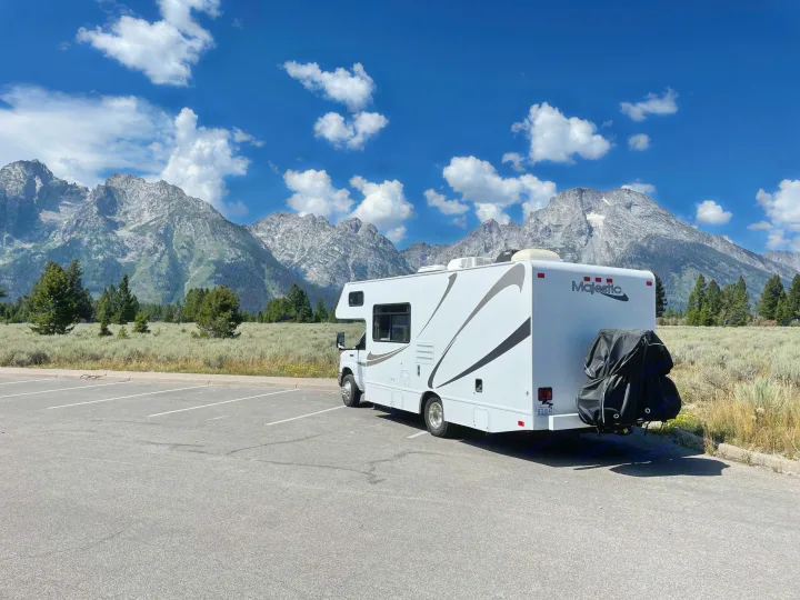 Scenic view of a Majestic rv rental with mountains & blue sky. Parked on asphalt lot.. Thor Majestic 2015