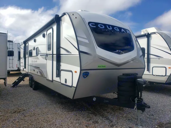 Sleek Cougar Half-Ton bunkhouse travel trailer, perfect for your next rv rental. Parked on gravel, ready for adventure.. Keystone RV Cougar 2024
