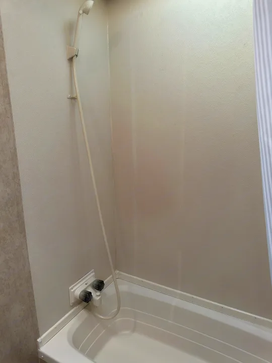 View inside an RV rental's compact bathroom, featuring a white tub, handheld shower, and water controls.. Forest River Salem Cruise Lite 2017