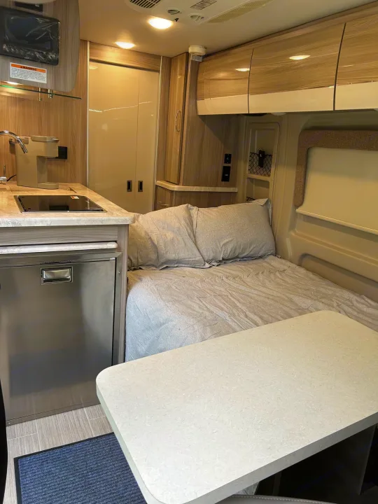 Cozy RV rental interior features a kitchenette, bed, and dining area, perfect for adventure.. Thor Scope 2022