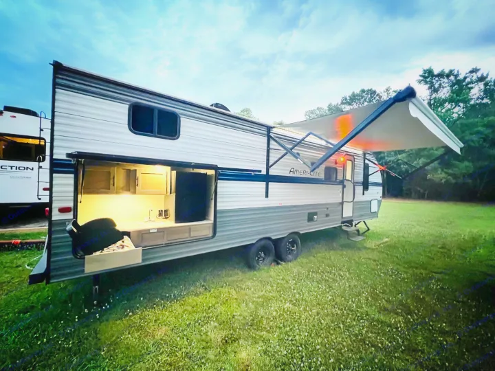 Enjoy your next adventure! This spacious rv rental features a bright outdoor kitchen and extended awning under a twilight sky.. Gulf Stream Gulf Stream 2021