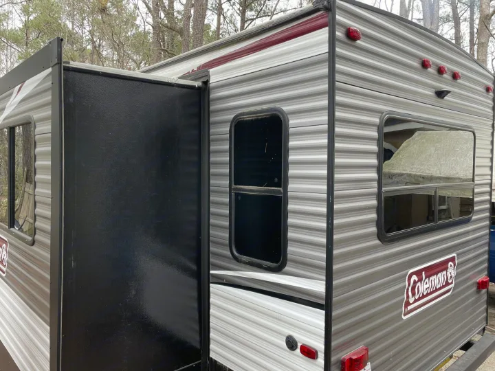 RV rental: A gray Coleman travel trailer with its large black slide-out extended, featuring multiple windows and rear lights.. Coleman Lantern 2019