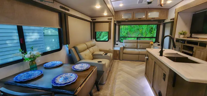 This inviting RV rental offers a spacious living area with recliners, dining table, and modern kitchen.. Forest River Hemisphere 2022