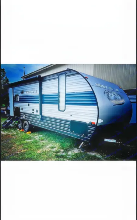 Modern Grey Wolf rv rental travel trailer, sleek grey/white/blue, parked on grass. Perfect for your next adventure.. Forest River Cherokee Grey Wolf 2020