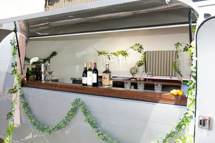 This RV rental is a chic mobile bar, beautifully decorated with greenery and ready to serve drinks at your event.. Airstream custom 1973